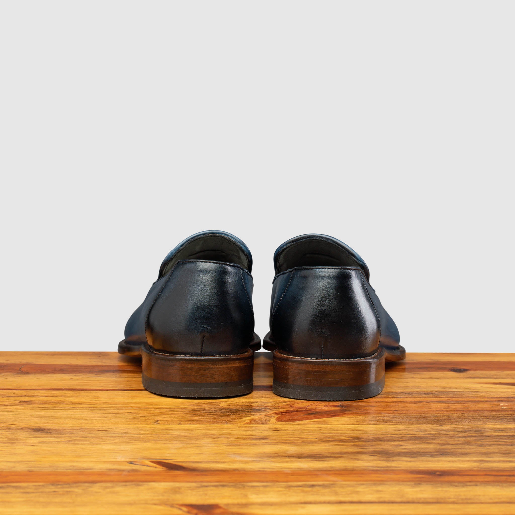 Back profile of Z993 Calzoleria Toscana Ocean Blue David Tassel Slip-On on top of a wooden table